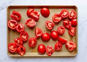 Halved tomatoes on a baking sheet.