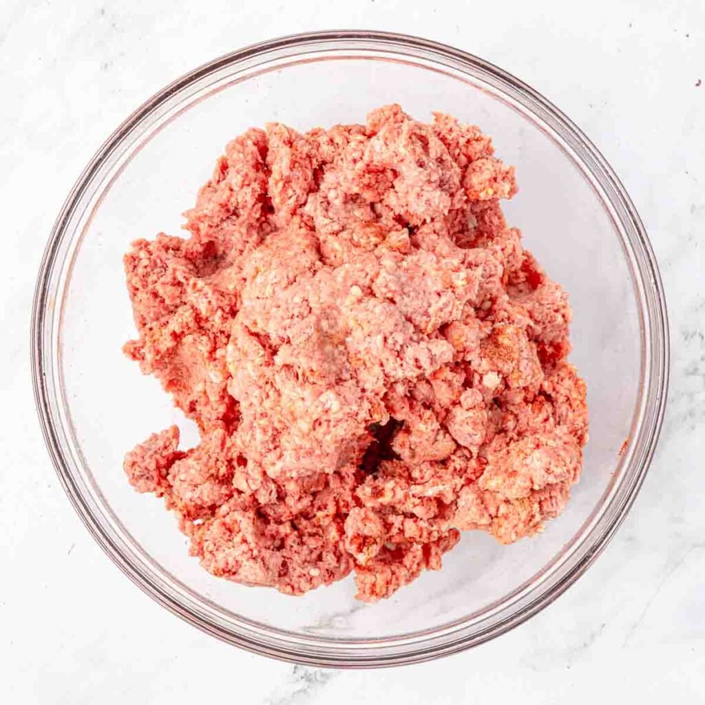 Raw ground beef in a mixing bowl.