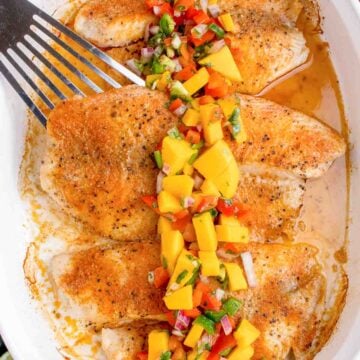 Baked Tilapia with seasoning and fresh mango salsa over top