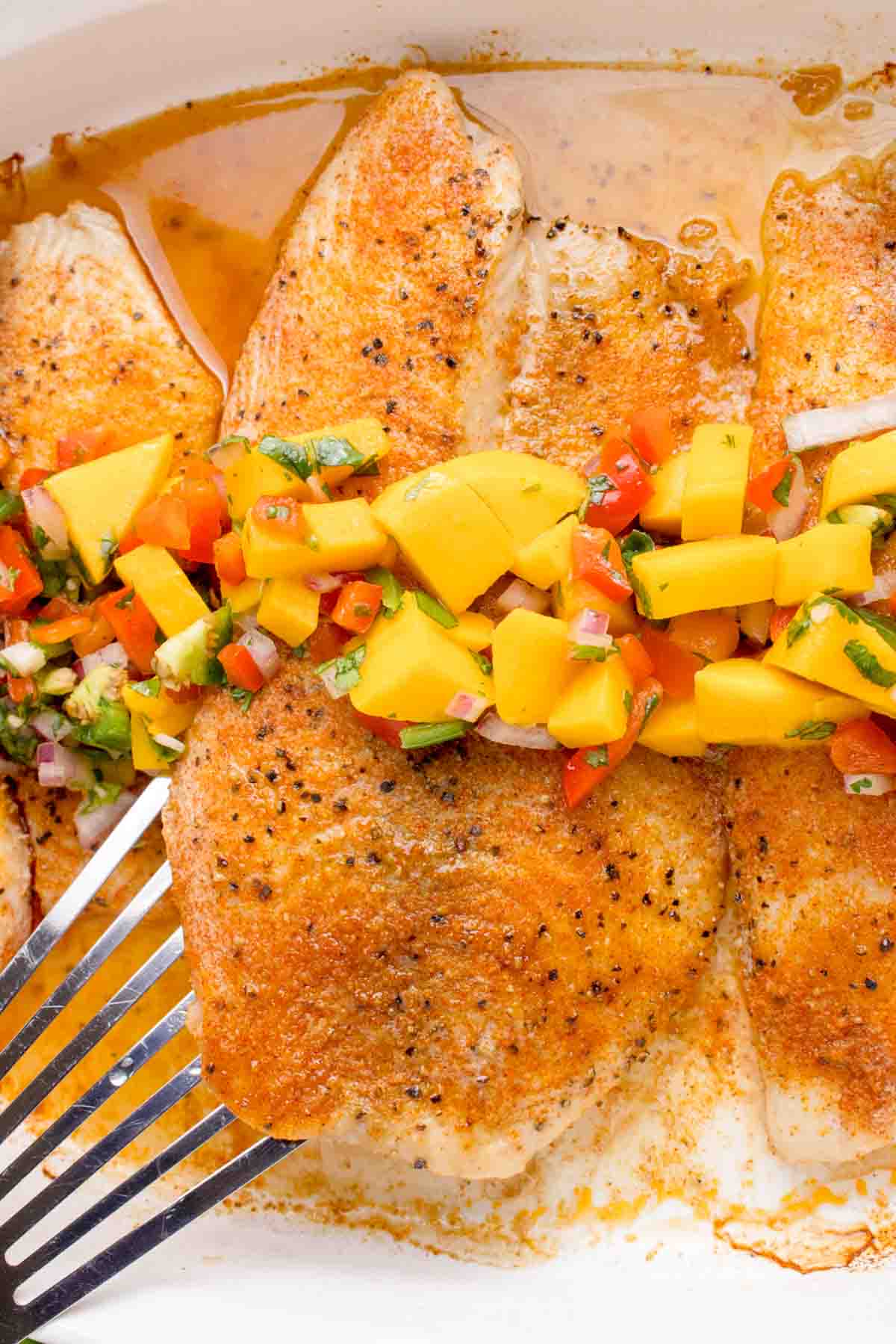 Baked seasoned tilapia topped with a homemade mango salsa