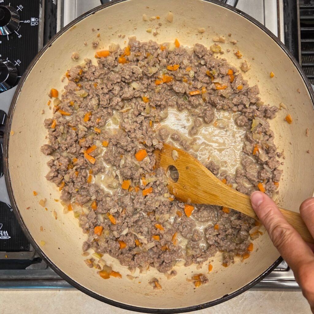 Ground beef and sofrito sauteeing in a pan.
