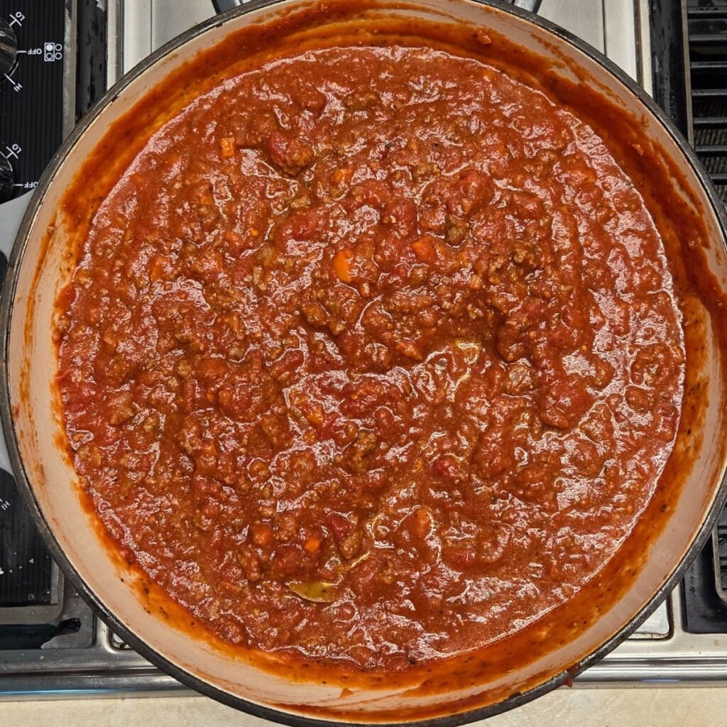 Bolognese sauce simmering in a pan.