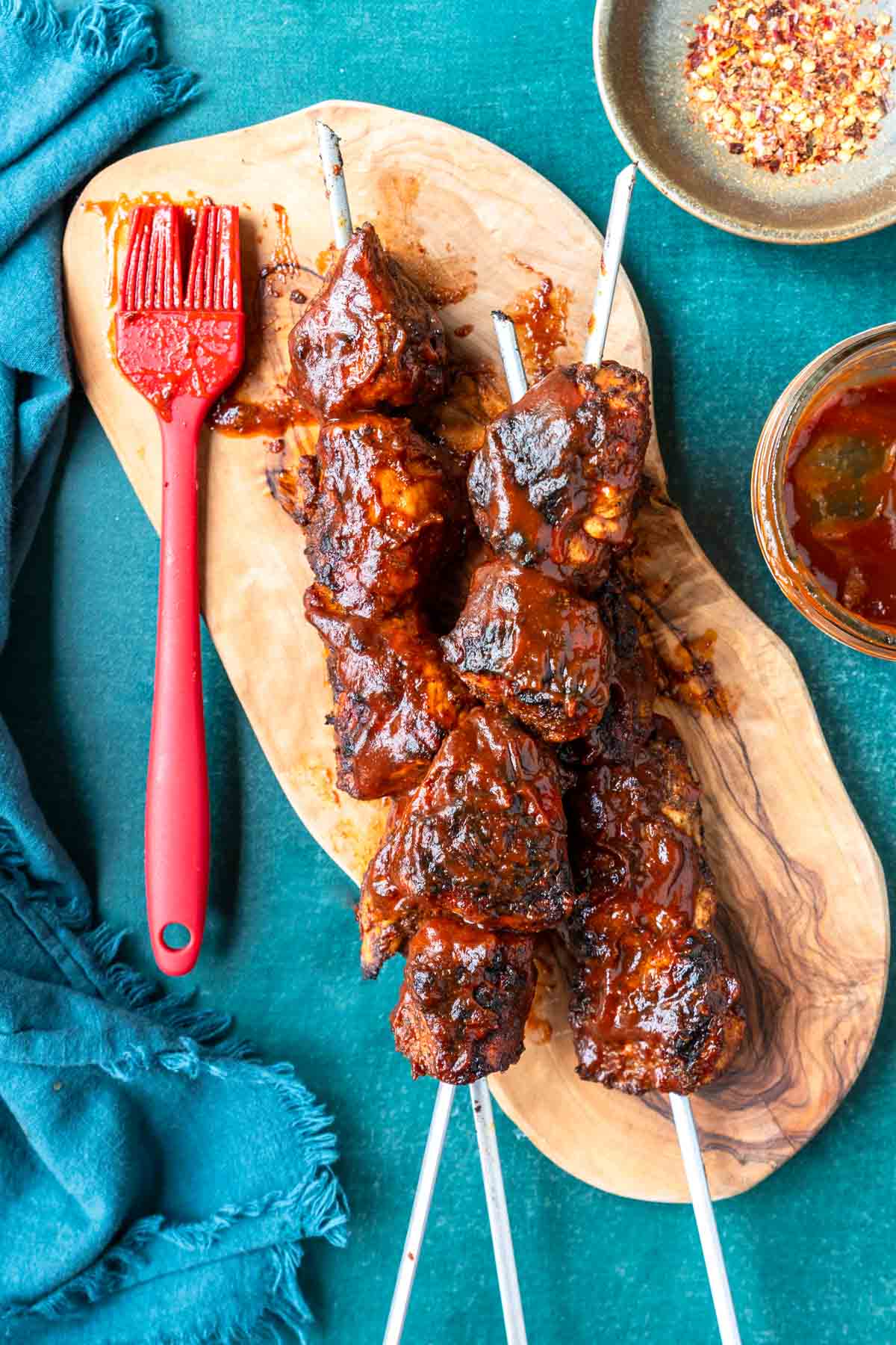 Basted with BBQ sauce, grilled chicken on metal skewers is ready to serve.