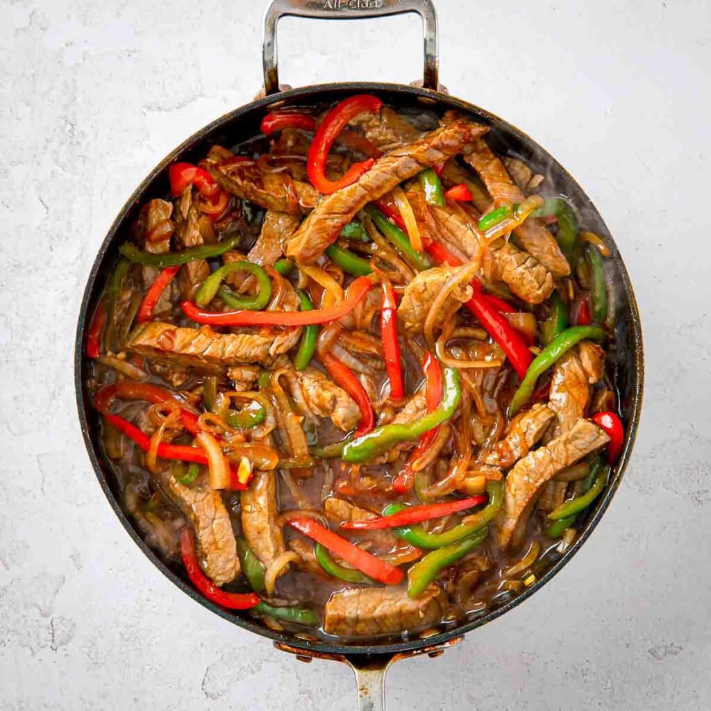Skillet filled with a Chinese pepper steak dinner.