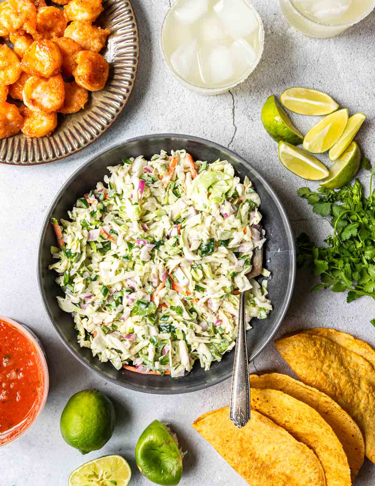 Fish taco slaw served in a bowl with a spoon in the mixture.