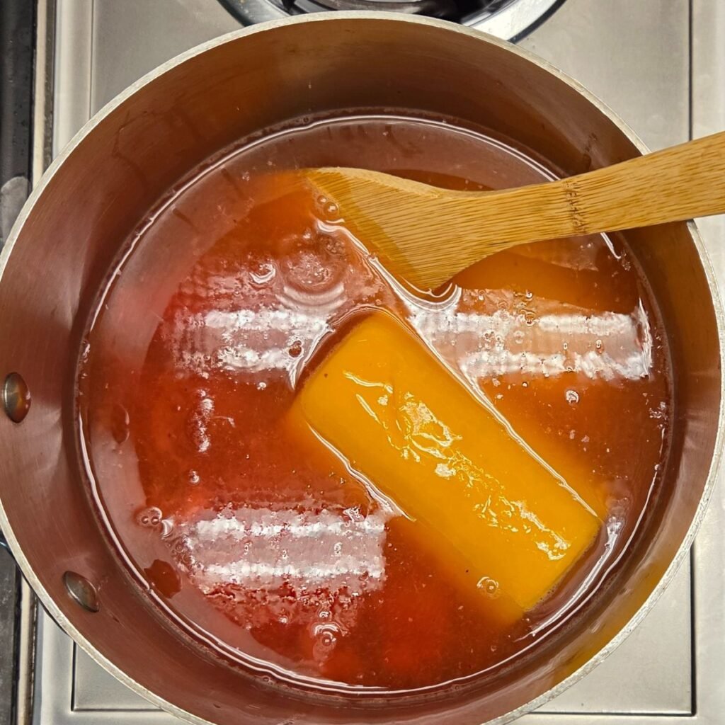 Oj and lemonade frozen concentrate melting in a pot with frozen strawberries