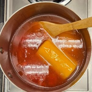 Oj and lemonade frozen concentrate melting in a pot with frozen strawberries