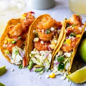 Three shrimp tacos with creamy crunchy coleslaw served in each one.