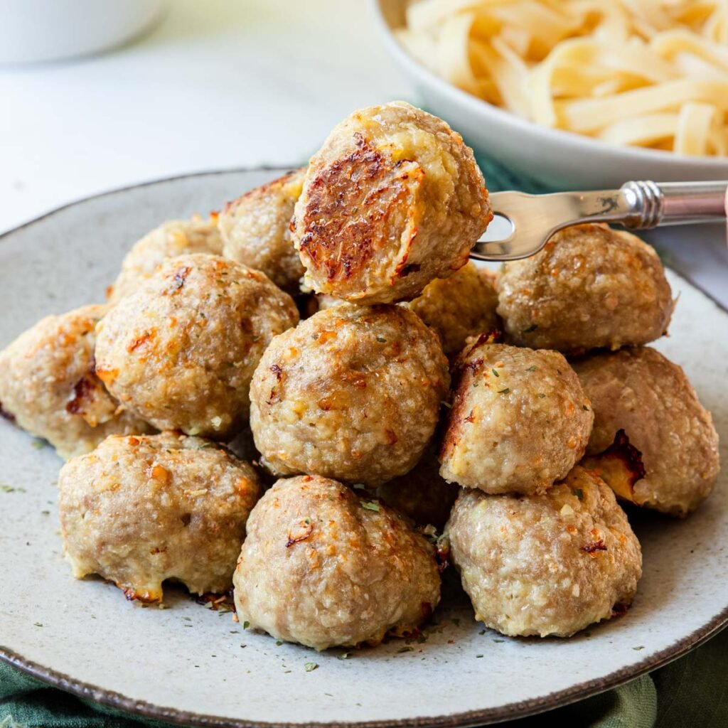 Stack of golden browned turkey meatballs on a plate.
