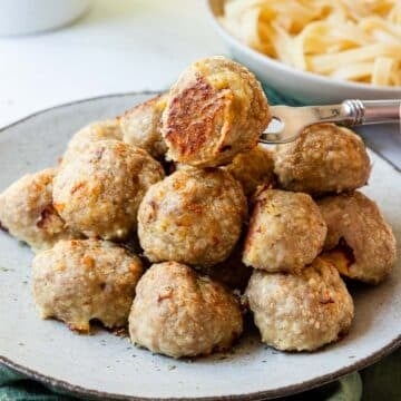 Stack of golden browned turkey meatballs on a plate.