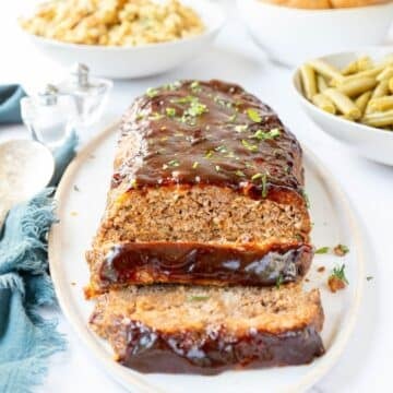 Barbecue Meatloaf on a platter with two slices cut
