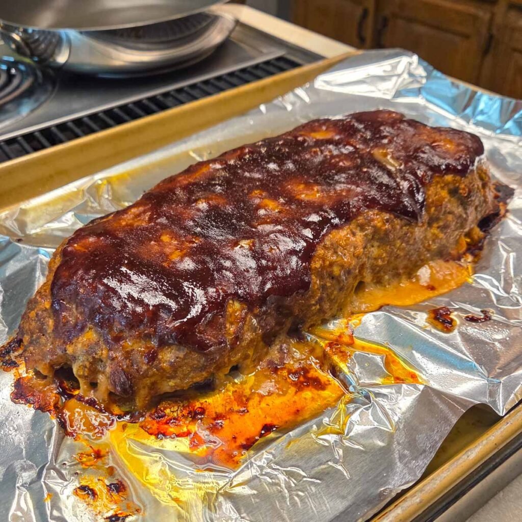 Side view of Barbecue Meatloaf sitting on a baking sheet.