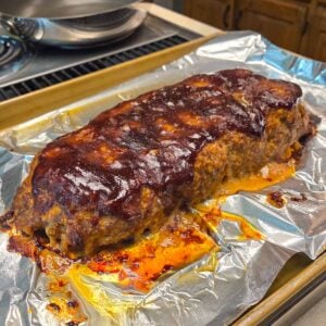 Side view of Barbecue Meatloaf sitting on a baking sheet.