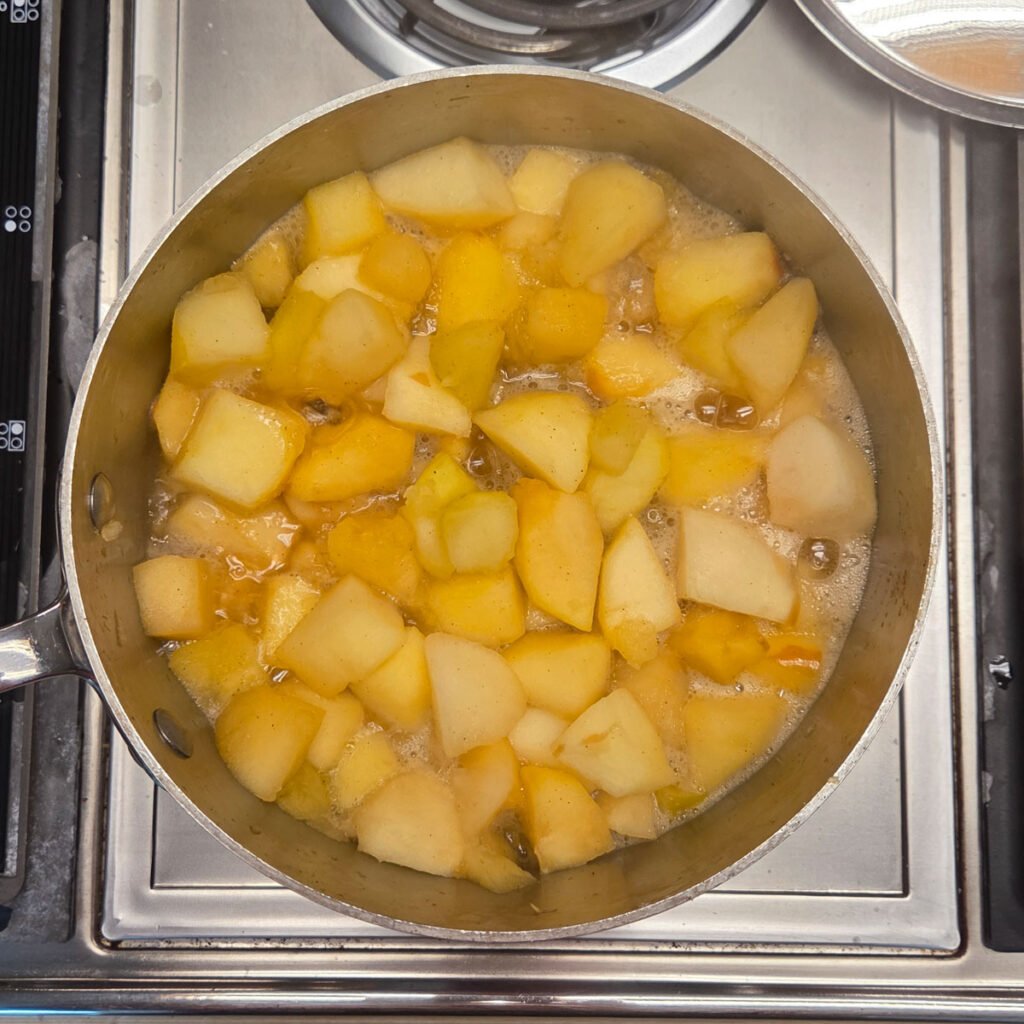 Apple chunks cooking down in a skillet.