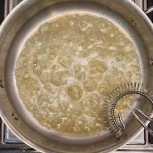 Melted butter and minced garlic sauteeing in a saucepan.