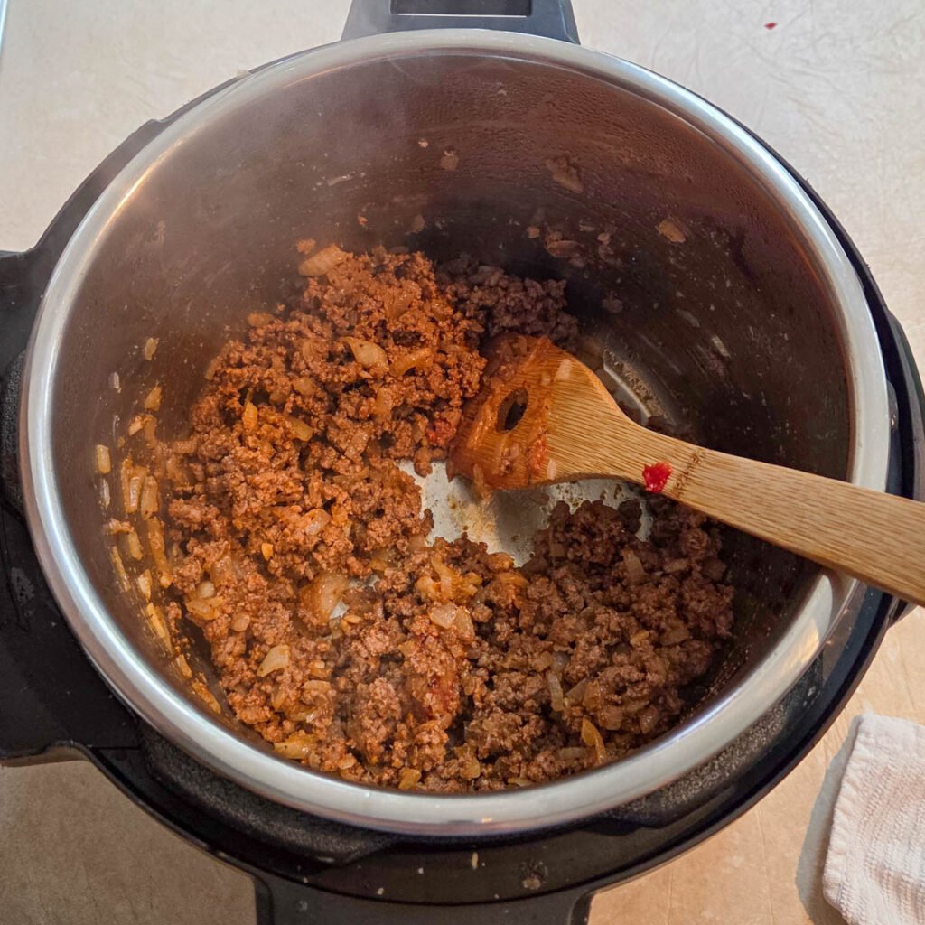 Tomato paste and garlic combined with the ground beef.