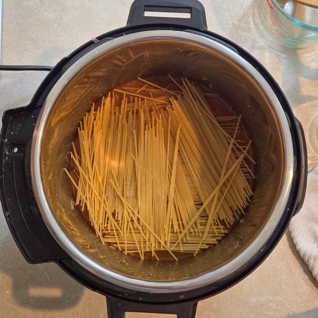 Dry spaghetti noodles added in a criss cross pattern so it cooks evenly.