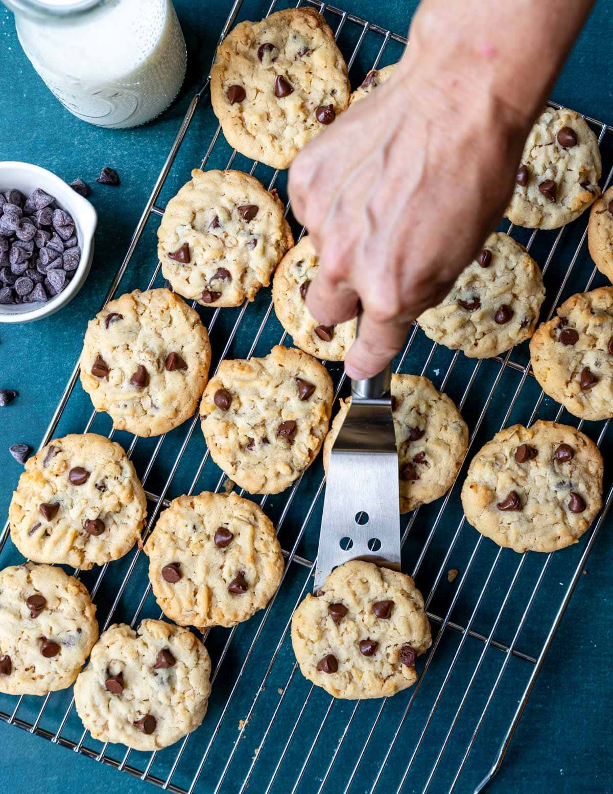 Spatula scooping up a cookie from the cooling rack.