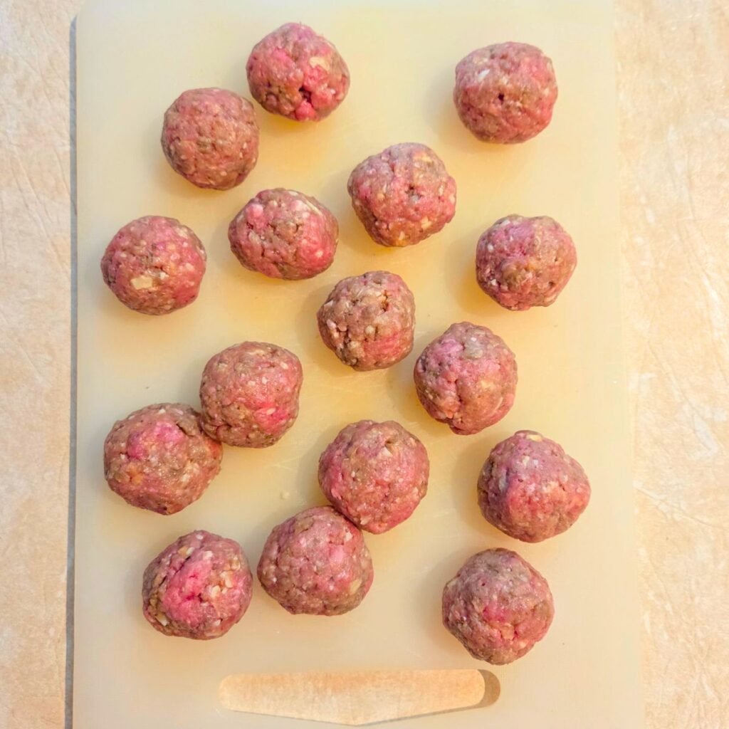 Raw meatballs shaped into balls.