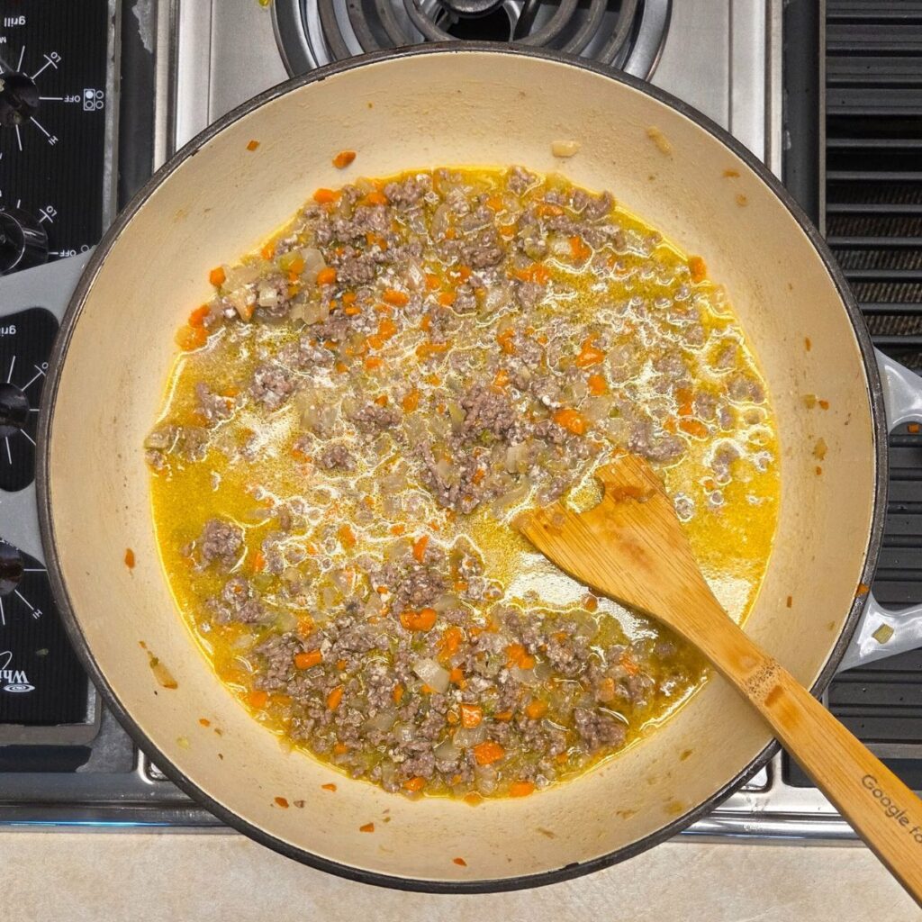 white wine, chicken broth, and milk added to beef and soffritto, making bolognese 