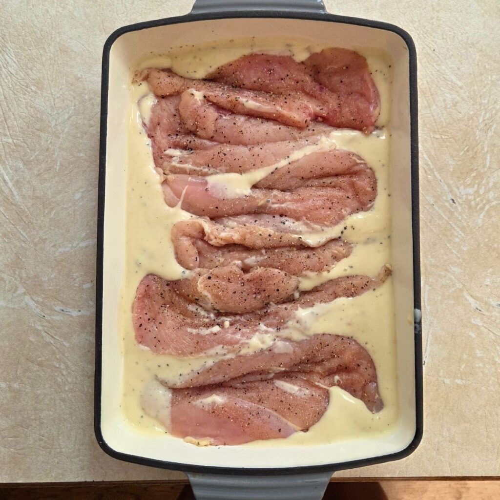 chicken breasts in a creamy sauce in a 9x13 pan