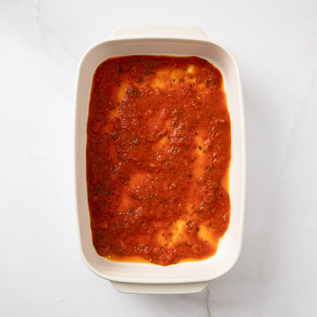 Store bought marinara sauce added to the bottom of a baking dish.