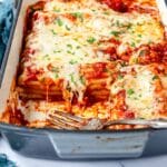 Close up of hot melty cheese over stuffed beef manicotti in a baking dish.