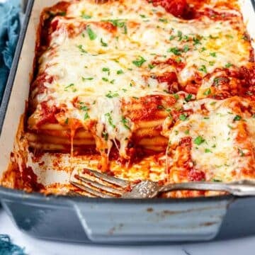 Close up of hot melty cheese over stuffed beef manicotti in a baking dish.