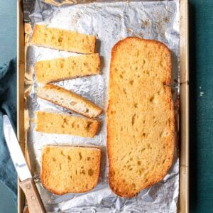 Garlic bread cut into slices on a baking sheet