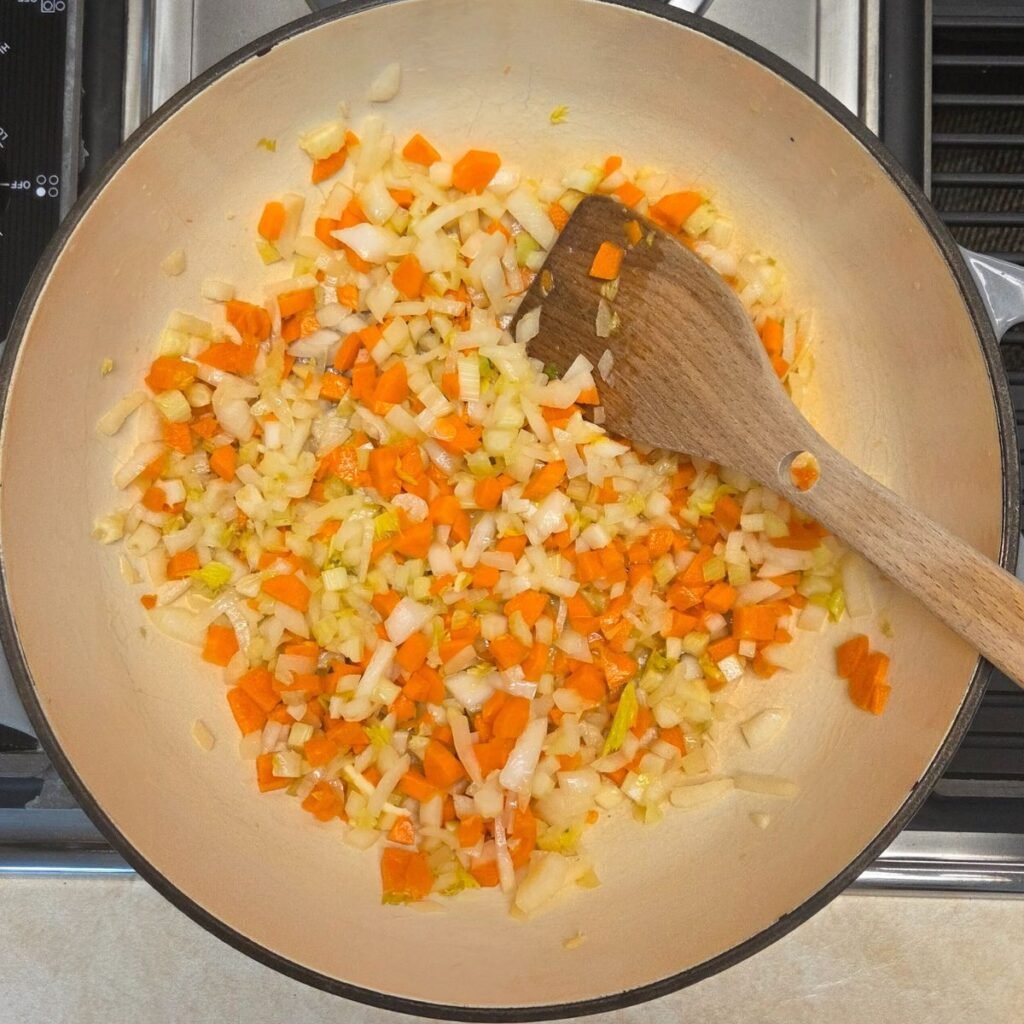 Diced onions, carrots and celery sauteeing in a Dutch Oven.