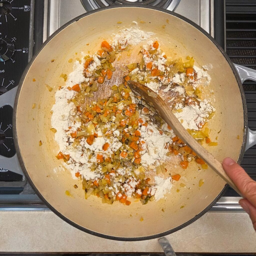 Flour added to the sauteed veggies in a coating to start a roux.