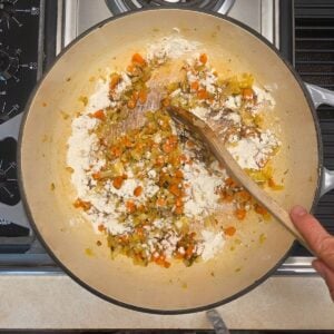 Flour added to the sauteed veggies in a coating to start a roux.
