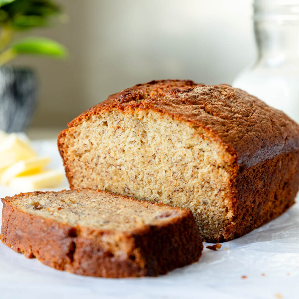 Golden brown banana bread with a thick slice cut away.