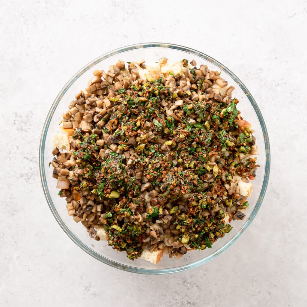 Filling for mushroom stuffing in a glass bowl with cubed bread.