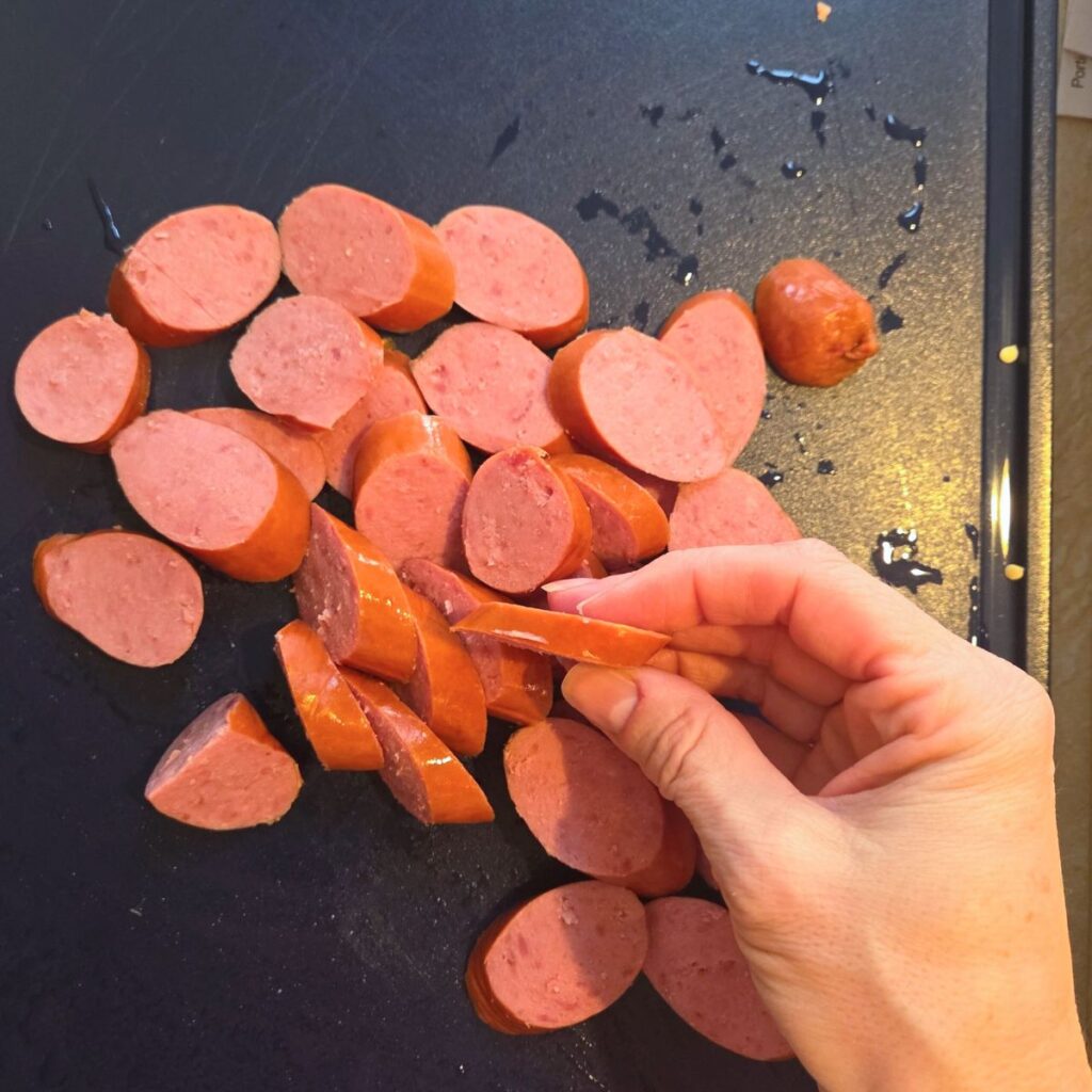 Sliced pieces of andouille sausage on a cutting board.