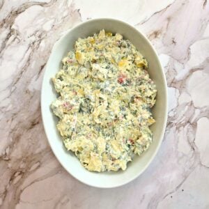 Spinach artichoke mixture added to an oval baking dish.