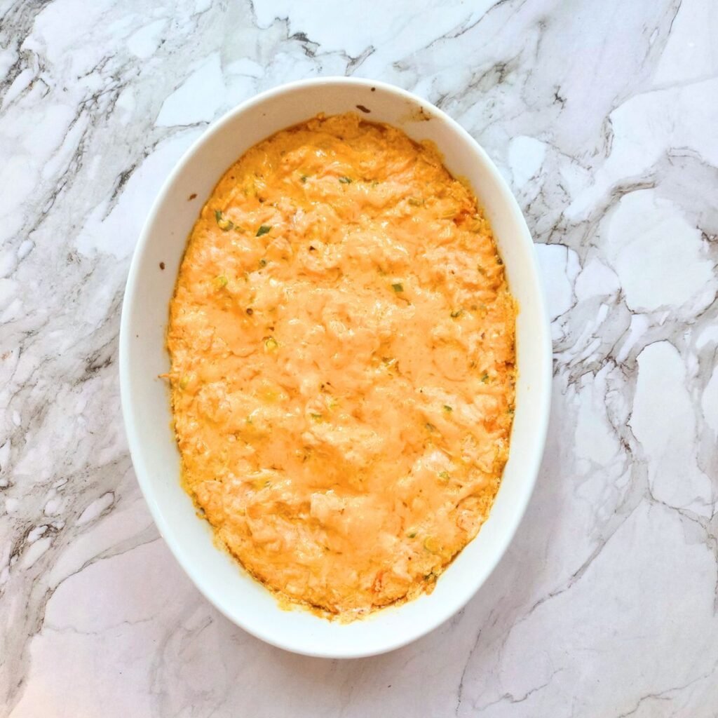 Just baked buffalo chicken dip in an oval serving dish.