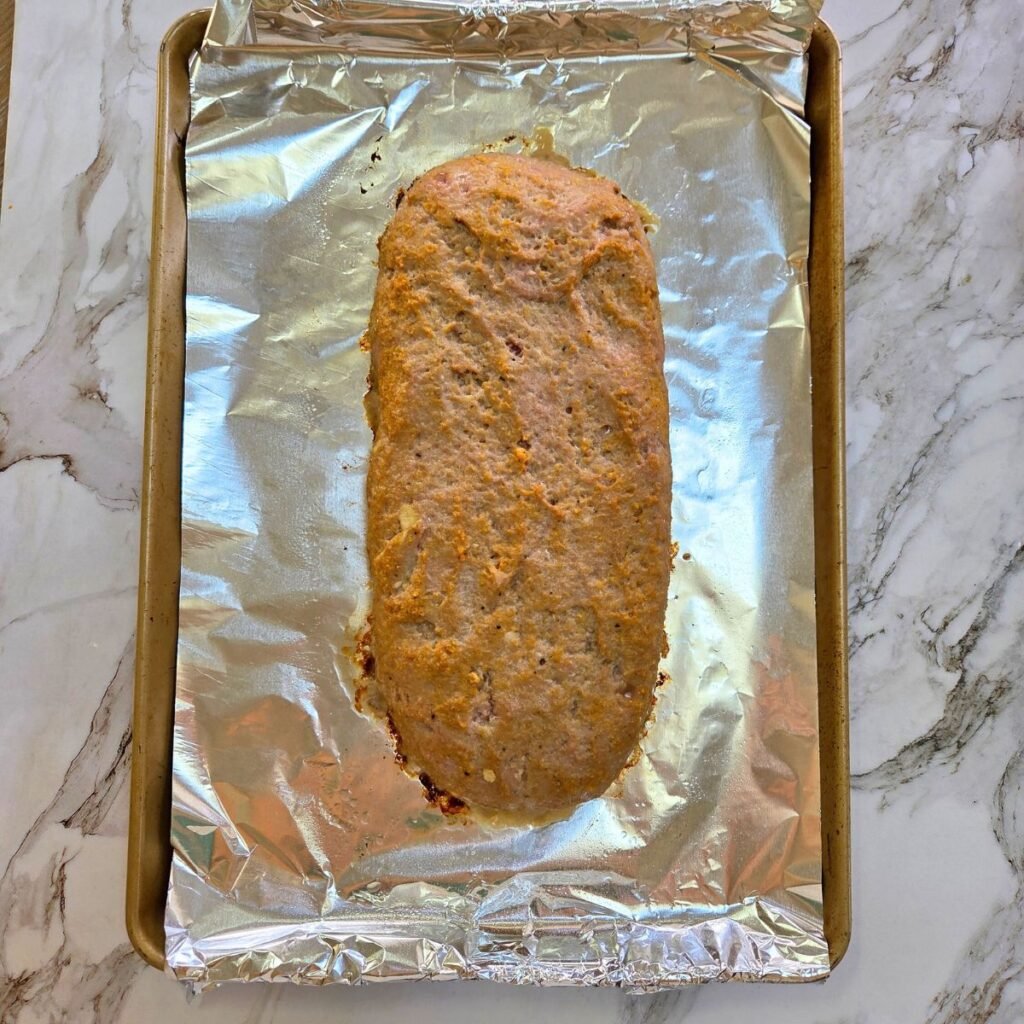 Baked ground turkey meatloaf on a baking sheet.
