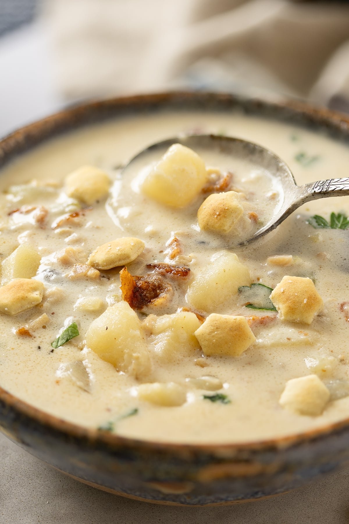 Close up of a bowl filled to the brim with rich and creamy clam chowder.