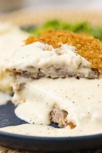 Gravy poured over a crunchy fried cubed steak.