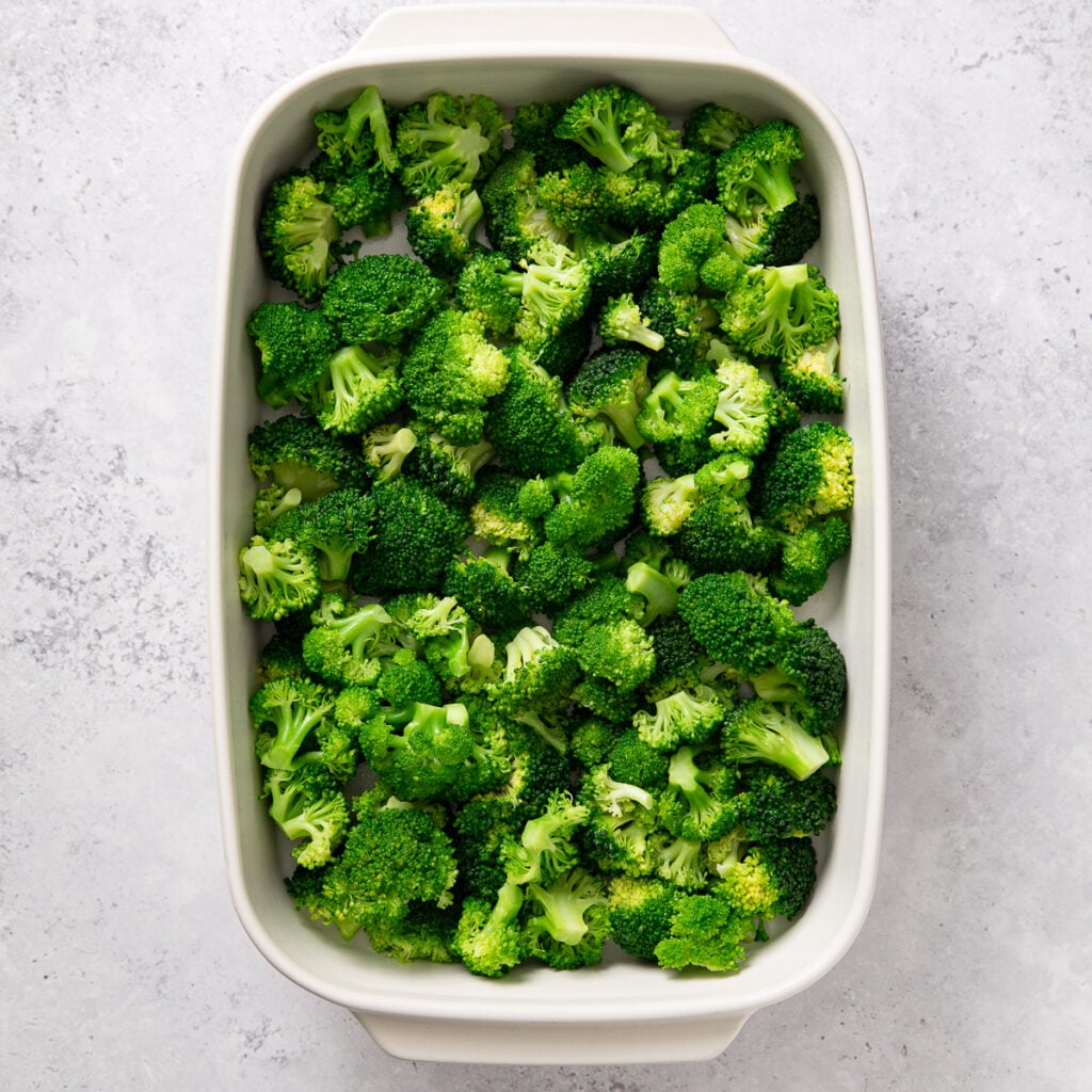Clean broccoli florets arranged in a baking dish.