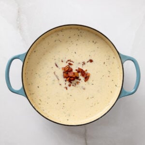 Crispy bacon added to a pot of clam chowder.