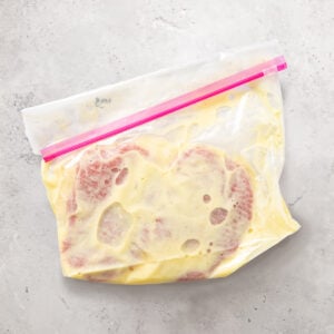 Cubed steak in a ziploc bag sitting in a marinade.