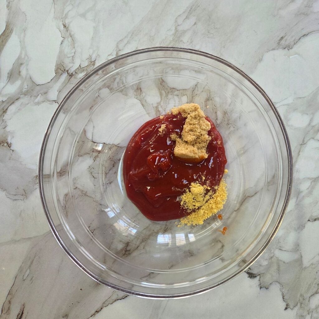 Sauce mixture ingredients measured and added to a glass bowl.