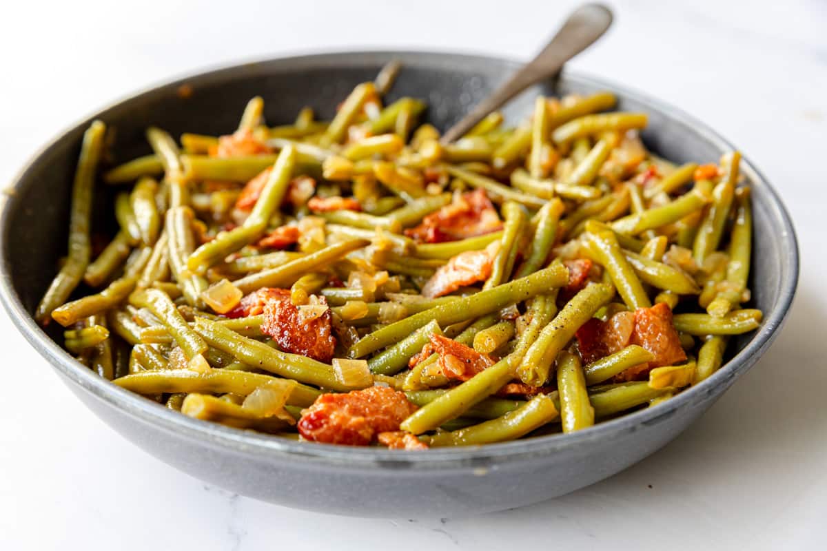 Spoon resting in a skillet with Southern Style Green Beans.
