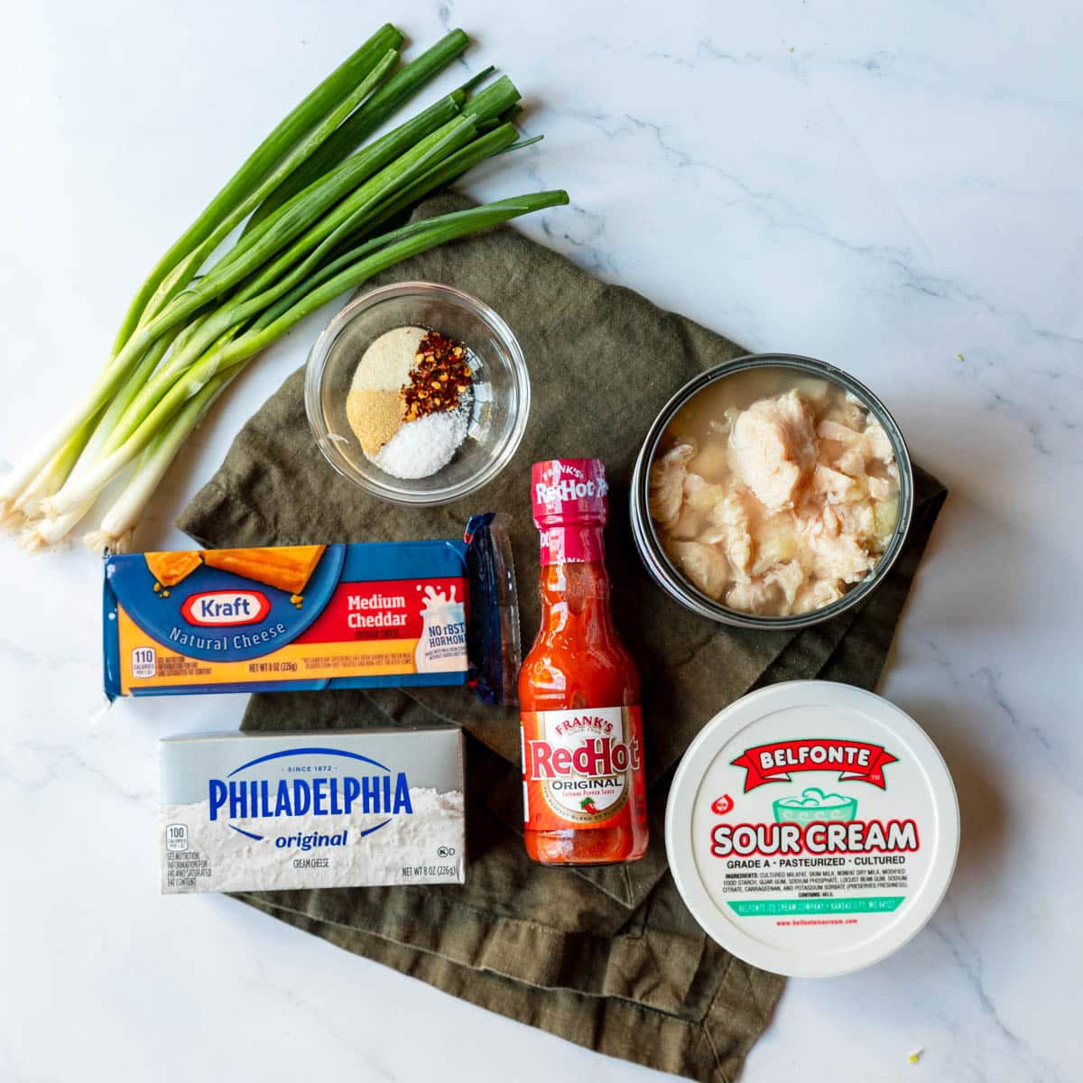 Ingredients shown are used to prepare buffalo chicken dip.