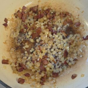 bacon and onions sauteeing in a dutch oven