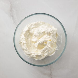 Whipped cream mixture in a glass mixing bowl.