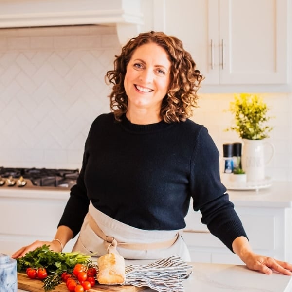 Susie Weinrich in a kitchen leaning on the counter