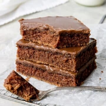 pile of three pieces of cake with a bite taken out of the top piece